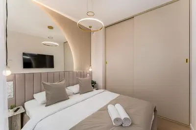 a bedroom with a bed and a tv on the wall at Glossy Apart G73 in Kraków