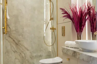 a bathroom with two sinks and a vase with flowers at Glossy Apart G73 in Kraków
