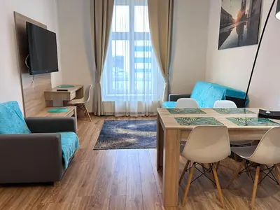 a living room with a table and chairs and a television at Old Town Apt - Bosacka B30 in Kraków