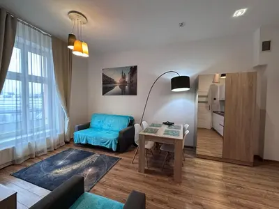 a living room with a blue couch and a table at Old Town Apt - Bosacka B30 in Kraków