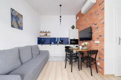 a living room with a couch and a table at Dietla Apartament z Klimatyzacją i Balkonem w Centrum Krakowa by Noclegi Renters in Kraków