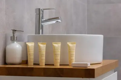 a bathroom sink with four measuring cups on a wooden shelf at Dietla Apartament z Klimatyzacją i Balkonem w Centrum Krakowa by Noclegi Renters in Kraków
