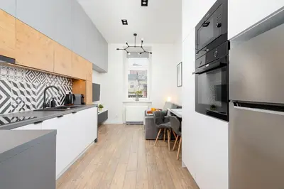 a kitchen with white cabinets and a counter top at Kraków Studio Wawrzyńca by Noclegi Renters in Kraków