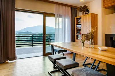 a dining room with a table and a large window at Domek Kordoń SPA Jacuzzi & Sauna in Zubrzyca Górna