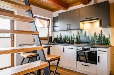 a kitchen with white cabinets and a stove top oven at Domek Kordoń SPA Jacuzzi & Sauna in Zubrzyca Górna
