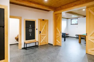 an open room with wooden doors and a table at Domek Kordoń SPA Jacuzzi & Sauna in Zubrzyca Górna