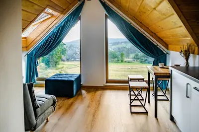 a living room with a large window and a table at Domek Kordoń SPA Jacuzzi & Sauna in Zubrzyca Górna