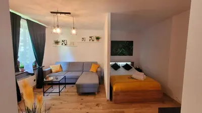 a living room with a couch and a bed at Apartament Joanna in Wadowice