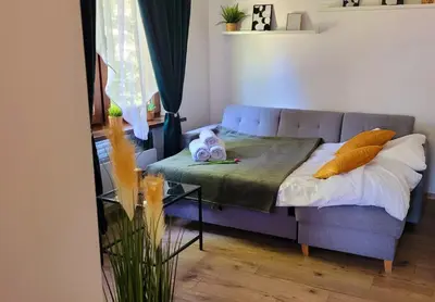 a living room with a couch and a bed at Apartament Joanna in Wadowice