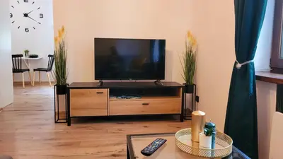 a living room with a flat screen tv on a entertainment center at Apartament Joanna in Wadowice