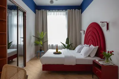 a bedroom with a large bed with a red headboard at Colorful 2-bed, 100sqm apartment in the heart of Kazimierz in Kraków