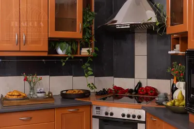 a kitchen with wooden cabinets and a stove top oven at Colorful 2-bed, 100sqm apartment in the heart of Kazimierz in Kraków
