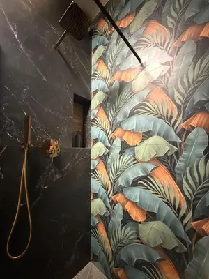 a bathroom with a mural of leaves on the wall at Deluxe Industrial Apartment free Parking in Kraków