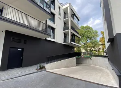 an apartment building with a parking lot in front of it at Deluxe Industrial Apartment free Parking in Kraków