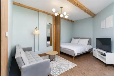 a bedroom with a bed and a couch and a table at Dietla ANTA Apartment in Kraków