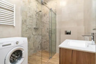a bathroom with a washing machine and a sink at Dietla ANTA Apartment in Kraków