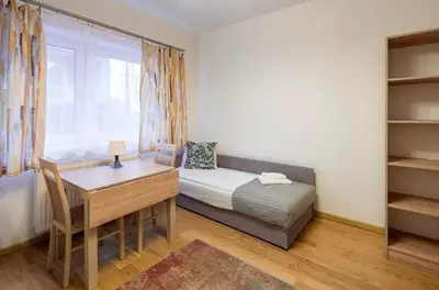 a room with a desk and a bed and a window at Pokoje na Sowiej in Kraków