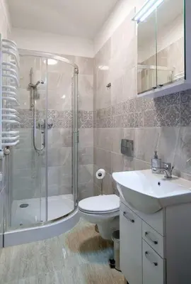 a bathroom with a shower and a toilet and a sink at Pokoje na Sowiej in Kraków