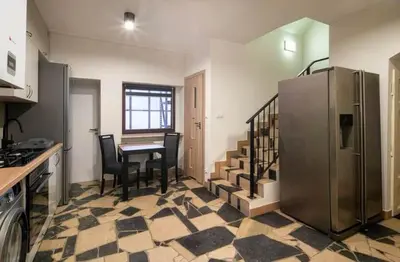 a kitchen with a table and chairs and a refrigerator at Pokoje na Sowiej in Kraków
