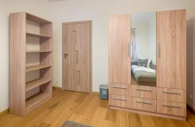 a large wooden dresser with a mirror in a room at Pokoje na Sowiej in Kraków