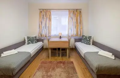 a living room with two beds and a table at Pokoje na Sowiej in Kraków