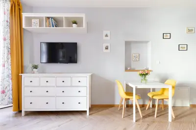 a dining room with a white dresser and a table at ANTA Apartments Plac na Groblach in Kraków