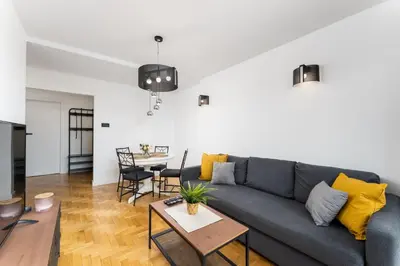 a living room with a blue couch and a table at Pachońskiego Urban Chic Apartment by BookingHost in Kraków