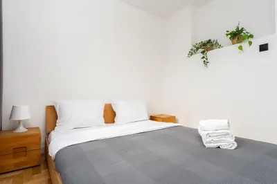 a bedroom with a large bed with a gray blanket at Pachońskiego Urban Chic Apartment by BookingHost in Kraków