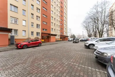 a red car parked on a brick street next to buildings at Pachońskiego Urban Chic Apartment by BookingHost in Kraków