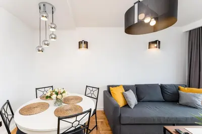a living room with a couch and a table at Pachońskiego Urban Chic Apartment by BookingHost in Kraków