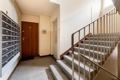 a hallway with stairs and a wooden door at Pachońskiego Urban Chic Apartment by BookingHost in Kraków