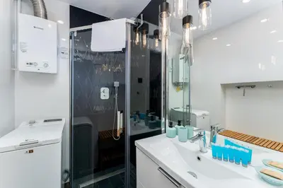 a bathroom with a sink and a shower at Pachońskiego Urban Chic Apartment by BookingHost in Kraków