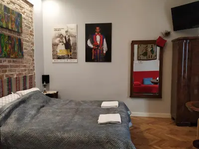 a bedroom with a bed and pictures on the wall at Krakowsky Apartment in Kraków