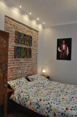 a bedroom with a bed and a brick wall at Krakowsky Apartment in Kraków