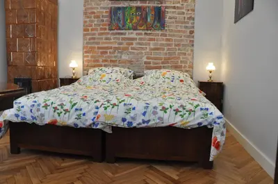a bedroom with a bed with a floral comforter at Krakowsky Apartment in Kraków