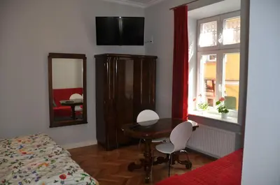a bedroom with a table and a mirror and a bed at Krakowsky Apartment in Kraków