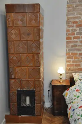 a room with a fireplace next to a bed at Krakowsky Apartment in Kraków