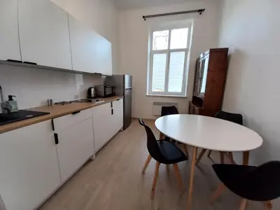 a kitchen with a white table and chairs and a table at Old Town - 2 bedrooms Sołtyka S3 in Kraków