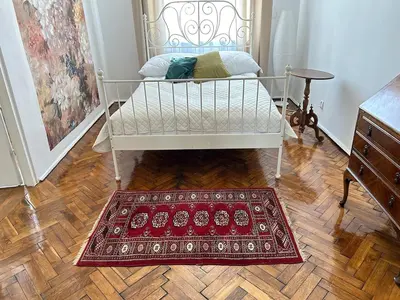 a bed in a room with a rug on a wooden floor at Old Town - 2 bedrooms Sołtyka S3 in Kraków