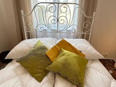 a white bed with two pillows and a metal headboard at Old Town - 2 bedrooms Sołtyka S3 in Kraków