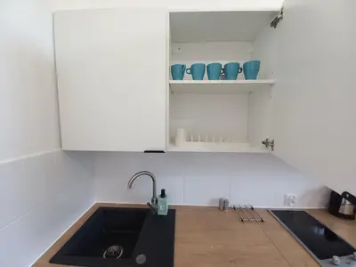 a kitchen with a sink and some cups and shelves at Old Town - 2 bedrooms Sołtyka S3 in Kraków