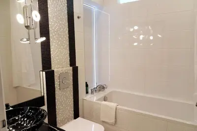 a bathroom with a tub and a sink and a toilet at Old Town - 2 bedrooms Sołtyka S6 in Kraków