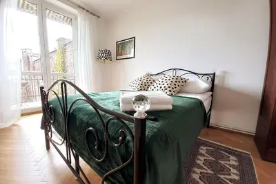 a bedroom with a bed with green sheets and a window at Old Town - 2 bedrooms Sołtyka S6 in Kraków