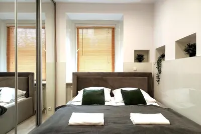 a bedroom with a large bed with two green pillows at Old Town Apt - Rzeszowska R6 in Kraków