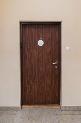 a brown wooden door in a white wall at Native Apartments Krupnicza 7 in Kraków