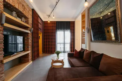 a living room with a brown couch and a tv at Native Apartments Krupnicza 7 in Kraków