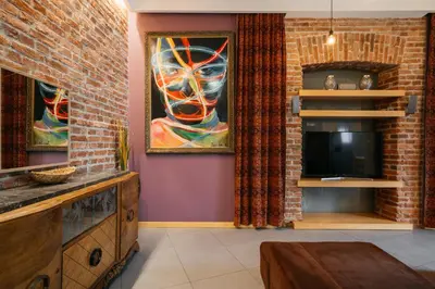a living room with a brick wall and a tv at Native Apartments Krupnicza 7 in Kraków