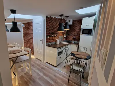 a kitchen with a table and two chairs and a counter at NestingHigh apartment in Kraków