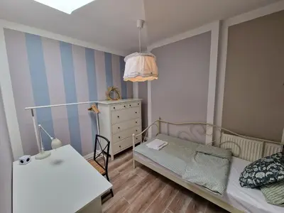 a small bedroom with a bed and a dresser at NestingHigh apartment in Kraków