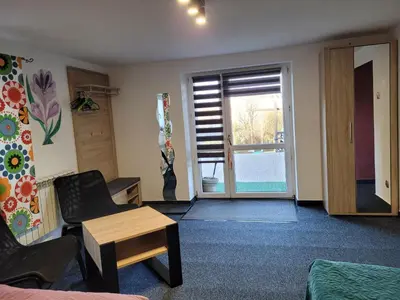 a living room with a couch and a table and a window at Apartamencik Pod Krokusem 2 in Rabka